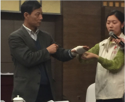 分组讨论会场，中国红十字协会向委员们分发了急救包，并现场讲解急救方法。