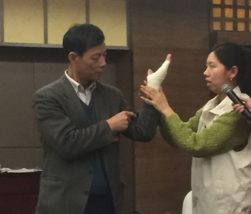 分组讨论会场，中国红十字协会向委员们分发了急救包，并现场讲解急救方法。